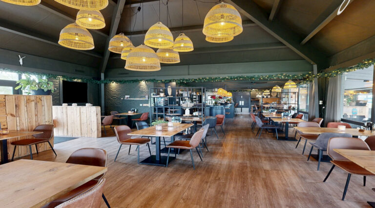 Interieur van Brasserie Knaag & Co met houten tafels en hanglampen